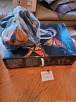 Box with Rollerblade label featuring butterfly image and plastic-wrapped boot of one inline skate on top