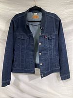 Front view of dark blue Levi's denim jacket showing button-down design and two chest flap pockets with buttons.