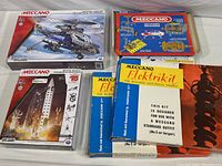 Photo showing all the Meccano kits together including Space Quest rocket, Mechanisms kit, helicopter kit box, and two Elektrikits.