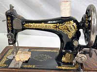 Front and side view of Singer sewing machine on wood case