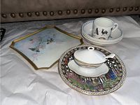 Full lot showing rectangular bird platter, sugar dish with spoon on decorative plate, and cup with saucer, all porcelain or ceramic items.