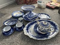 Full lot arranged showing all pieces including teapot, plates, fan dish, platter, cups with saucers, butter dish, egg holder bowl