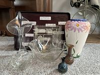 All items displayed together on carpet showing bowls, vases, and trays