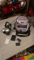 Image showing Sony CD Mavica camera, battery charger, two batteries, and camera carrying case on a table.