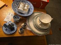 Overall view of mixed china items including bowl, napkin holders, Lenox plates and cup, and cruets