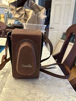 Brown leather carrying case with 'Cira-flex' embossing, strap visible.