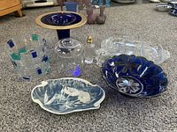 Photo showing all items on floor including cobalt blue glassware, Inoclay dish, ice bucket, lidded container, sugar dish, salt shaker, etched platter