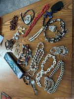 Overall assortment of costume jewelry including various necklaces with different bead styles and materials, sterling and rhinestone earrings in different styles, two ladies watches.