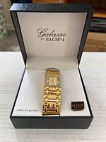 Gold tone Elgin Galaxie watch in its original box, with label showing $125 price and note of long life battery.