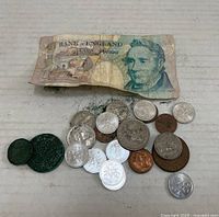 Photo of assorted coins and one £5 Bank of England note laid out, showing condition and details of currency.