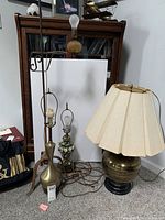 Photo showing all four lamps together: three table lamps with different bases and one minimalistic floor lamp with amber glass base