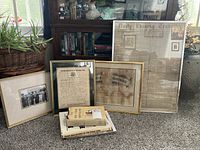 Framed black and white military photograph, honorable discharge paper from 1918, certificate of confirmation, and a 1870 newspaper page arranged behind four books about military and world wars.