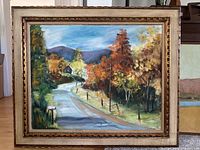 Full front view of the framed landscape painting showing road, house, trees with fall colors and distant hills.