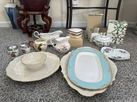 Wide image showing an assortment of Lenox and Mikasa serveware including chip and dip platter, serving platters, ceramic dishes, and boxed Mikasa soup bowls.