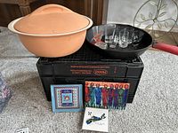 Full lot showing Lodge cast-iron pan, Schlemmertopf dish, shot glasses on pan, trivets in front.