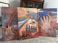 Three signed paintings by J. Kim displayed standing on floor showing abstract hands, figures, and organic patterns