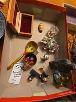 Wide view of assorted figurines and decorative items inside a box