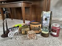 Full lot showing planters, paperweight, crystal ornament, snow globe, candle, figurines, doll stands, menorah, basket, decorative storage box