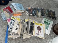 Shows spread of various Playbills and opera programs arranged on carpet with some loose stacks and plastic protective sleeves.
