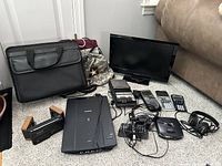 Image showing all items including monitor, scanner, tape recorder, calculators, briefcases, and portable CD player with headphones arranged on carpet