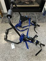 Full view of Thule bike rack showing black metal frame and blue securing straps