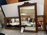 Two wall mirrors with wood frames, photographed together, showing sizes and reflective condition.