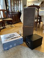 Photo showing the original box of the Audio-Technica AT-LP60 USB turntable, the S Point Source PS 100 speaker, and two vintage Scott speakers stacked with brown fabric grills and wood cabinets in a living room setting.