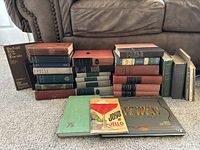 Overview image showing stacked vintage and antique books of varied sizes and colors, plus visible titles including Portrait Life of Lincoln, Boston A Guide Book, and vintage cookbooks like Joys of Jello.