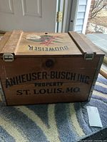 Front side of the wooden crate showing Anheuser-Busch Inc. property text with city St. Louis, MO.