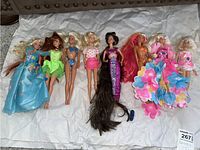 All seven dolls arranged on white background showing different outfits and hair colors.