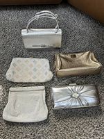 Overview of the full lot of five vintage evening purses on carpet including metallic and beaded varieties