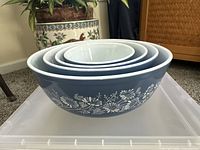 Set of 4 vintage Pyrex colonial mist mixing bowls nesting inside each other showing exterior floral pattern and blue color.