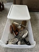 Plastic bin with five vintage wood and metal shoe trees inside, showing the whole lot together.