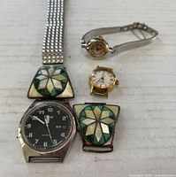 Photo showing all three wristwatches: Pulsar quartz watch with embellished band and extra clip, Omega Ladymatic watch with mesh band, and small Wittnauer watch without band.
