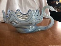 Side view of blue Murano style glass swan bowl showing detailed swirled glass and wavy rim
