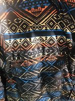 Close-up of the coat's geometric patterned fabric showing colors and design.