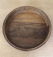 Top view of round wooden serving tray showing natural wood grain and stamped Dansk logo on bottom