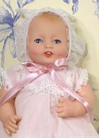 Front close-up image of the Effanbee Bubbles baby doll showing detailed facial features, bonnet, ribbon, and lace on the dress.