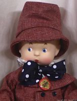 Close-up of Effanbee Skippy doll's face and hat showing detailed facial features, blue eyes, red checkered hat, and large navy blue polka dot bow tie.