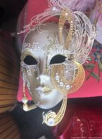 Front and side view detail of the 12-inch gold theatrical decorative mask with pearl and rhinestone filigree design.