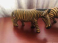 Photo of one wooden carved zebra figurine painted with black stripes on yellow base