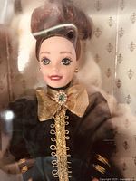 Close-up frontal view of Yuletide Barbie doll in box showing doll's head, face, and upper torso, highlighting detailed clothing and accessories.