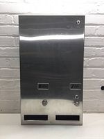 Front view of the stainless steel hygiene dispenser showing coin slots, dispensing buttons, and lock mechanisms.