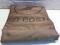 Folded La Poste bag with visible logo and striped pattern on material.
