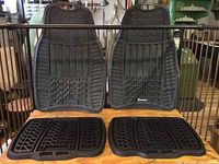 Four Michelin car rubber mats, two large front mats and two smaller rear mats shown together with visible tread patterns and handles.