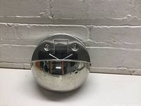 Front view of the round stainless steel wall mount ashtray showing polished metal surface and mounting screws.
