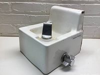 Front and right side view showing the white ceramic fountain, chrome spout and push button, American Standard branding on side, and overall shape.