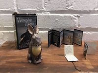 Front view of the hand painted General Woundwort ceramic figurine from Watership Down with original box and pamphlets in background.
