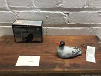 Overall view of the figurine on wooden surface with original box and informational cards