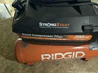 Top view showing StrongStart and Quiet Compressor 77 dBA labels, and spec sticker